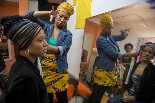 SSusan Meiselas / Magnum Photos; with the support of Save the Dream, Instituto Moreira Salles and ESPN BRAZIL. Bairro de Fátima, Rio de Janeiro. July 11, 2014. Fabiola shows Anne how to wrap her hair naturally in a turban at the store Colares Odara.