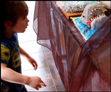 phil and yvonne morton;Shark Cake; At Piha last weekend they celebrated ten successful years at the gallery  with a bling day and a competition for decorated cakes.  This gruesome shark cake caused a delicious stir of fear   with the children.