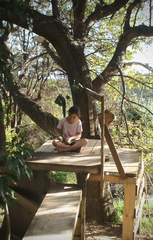 Jane Scorey; weaving in her tree hut; Teeana weaving harakeke in her tree hut, Ostend, Waiheke Island.