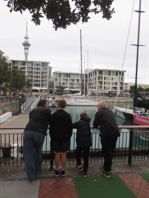 matt byford;Conversation about Auckland;One of my favourite places in Auckland with my eyes filled with magnificent Americas Cup yachts, the skyline and the restaurant where i work.  This spot reminds me of happy times but i wonder what these friends/family are thinking as they stand there.