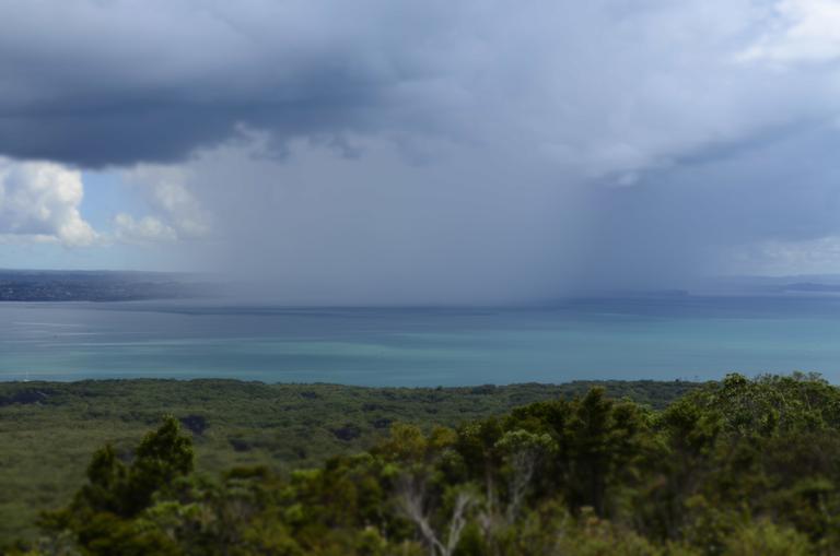 Jago Neal; Rain coming in; I was taking a group of students up Rangitoto island. We had reached the top and were admiring the view of Auckland when we saw this rain cloud coming towards us. Then it was a race back down to the boat. The rain cloud won the race!