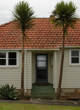 Darius Mccallum; cabbage tree sentinels guard the entrance; old state house in Northcote