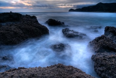 Ewen Cafe; Piha Dusk; I wanted to capture the feeling of motion and depth of the waves breaking around Lion Rock, Piha. Image made from 3 exposures blended to capture shadows and highlights.