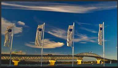 phil and yvonne Morton;approaching sunset; Flags at Westhaven Yacht Basin snap in the breeze as the harbour bridge catches the last of the evening light.