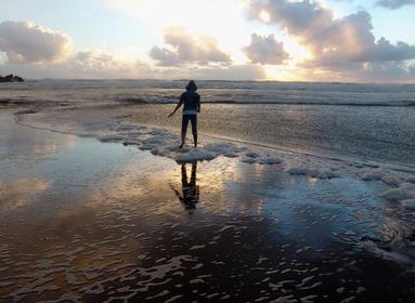 ES, Han;Raining piha beach; but she is having fun at beach