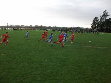 Anoj Kumar; 10 players chasing one soccer ball; Nirav Kumar playing in red