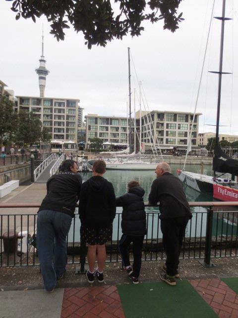 matt byford;Conversation about Auckland;One of my favourite places in Auckland with my eyes filled with magnificent Americas Cup yachts, the skyline and the restaurant where i work.  This spot reminds me of happy times but i wonder what these friends/family are thinking as they stand there.