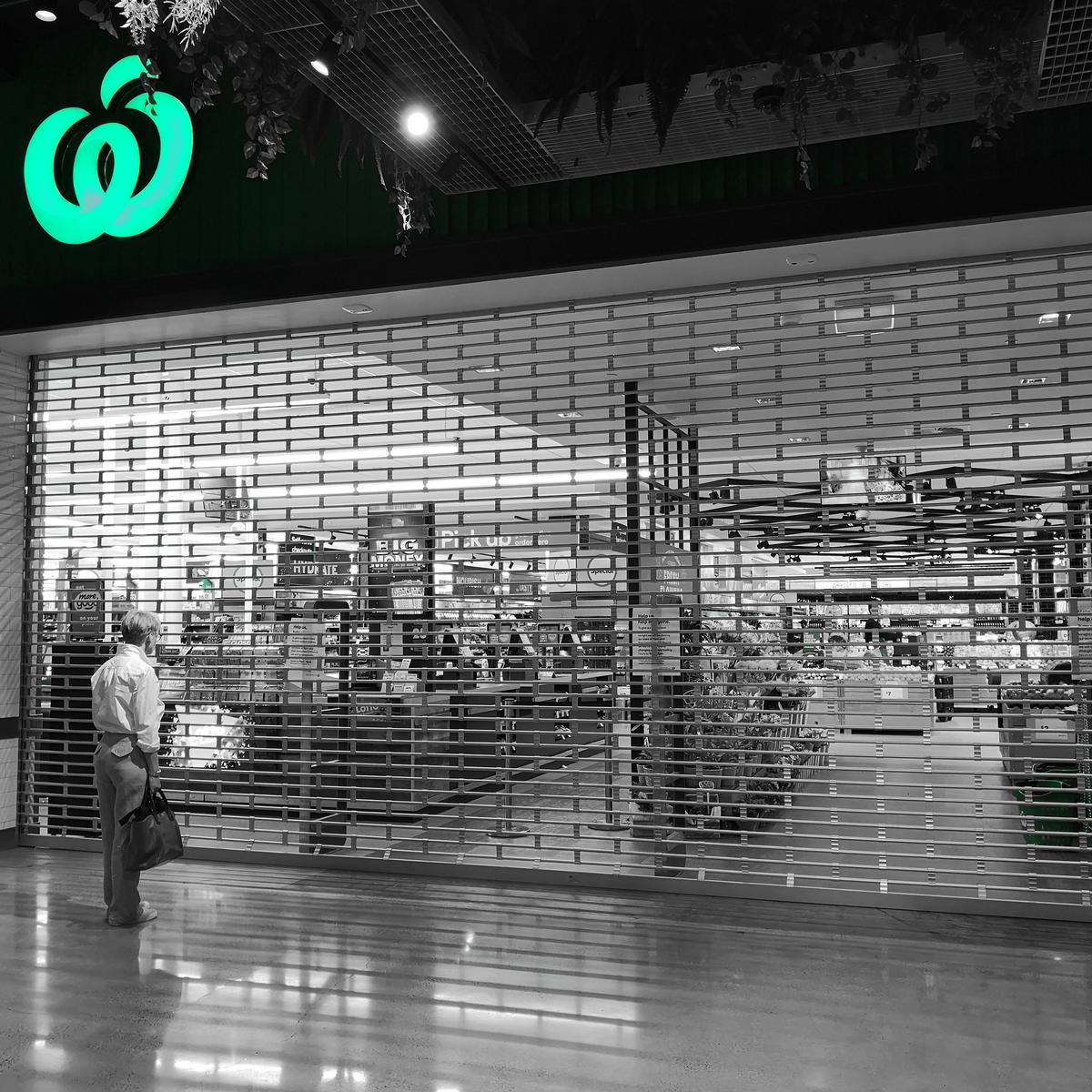 Tiffany Li; Window Shopping; An elderly man looks forlornly through the bars.  Will the shelves be restocked today?