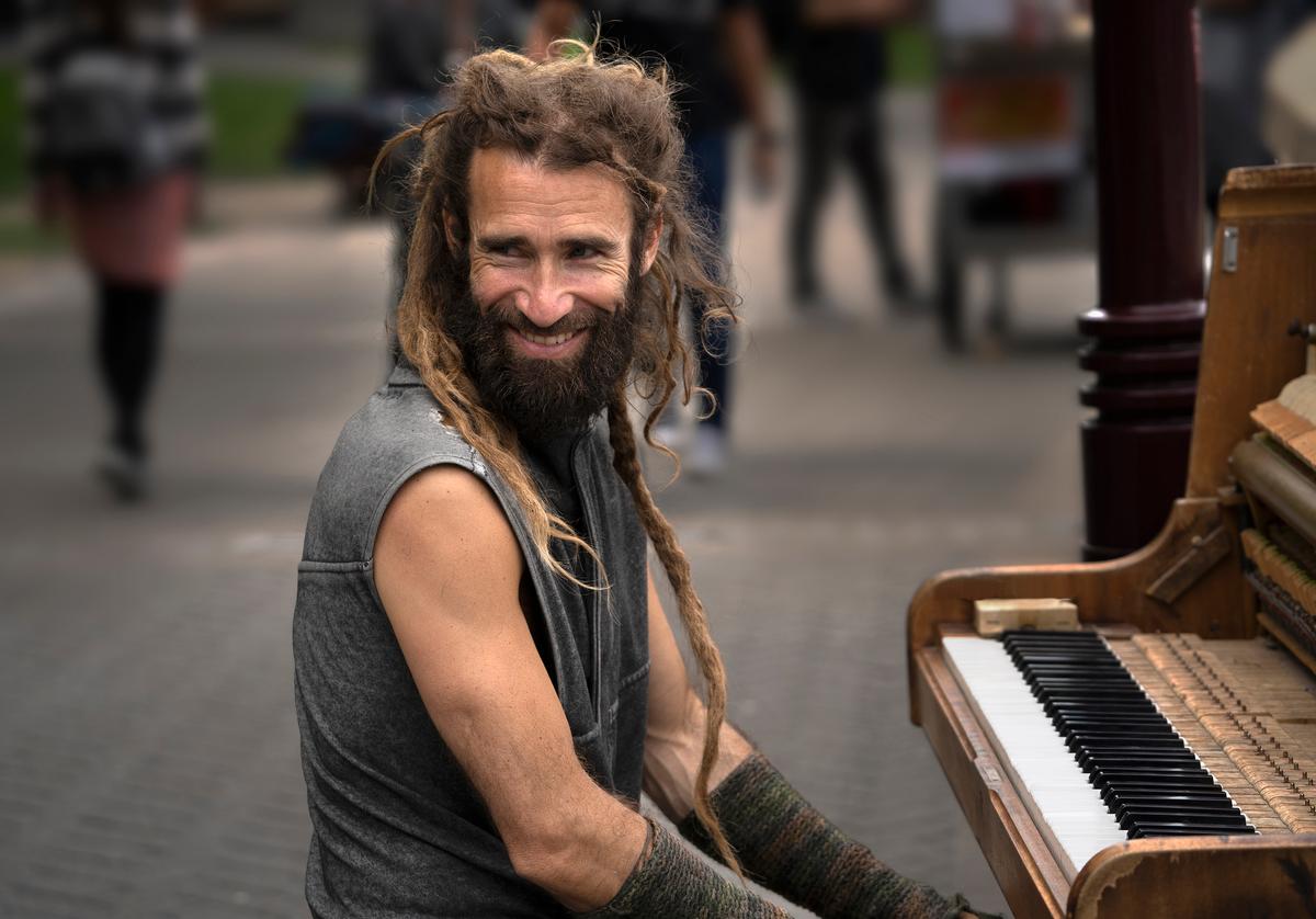 Jiongxin Peng; Street Artist; 07/11/2018, 11:30am, in Queenstown, New Zealand, a street artist plays piano in the street