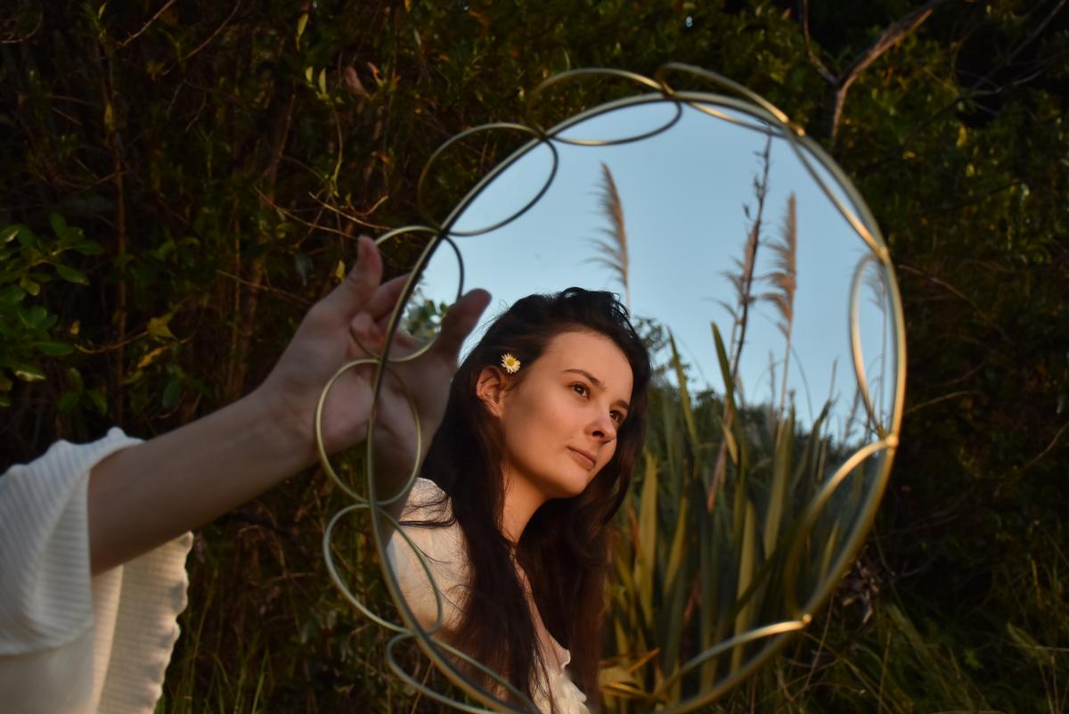 Gemma Monk;Looking at how nature surrounds us   through another point of view.;This image is taken using a mirror in a forest. The mirror shows a model surrounded by nature.