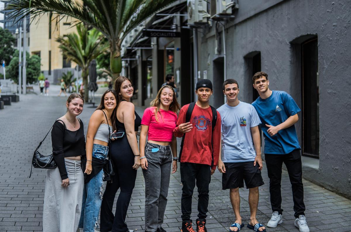 LEYAO LIU;Street Vibes;A group of young strangers posing for a friendly shot on the sidewalk. They were asking for this random photo when I was doing street photography with my friend. They radiate confidence and style as they smile at the camera. This photo captures the essence of street photography: unexpected encounters and connections.