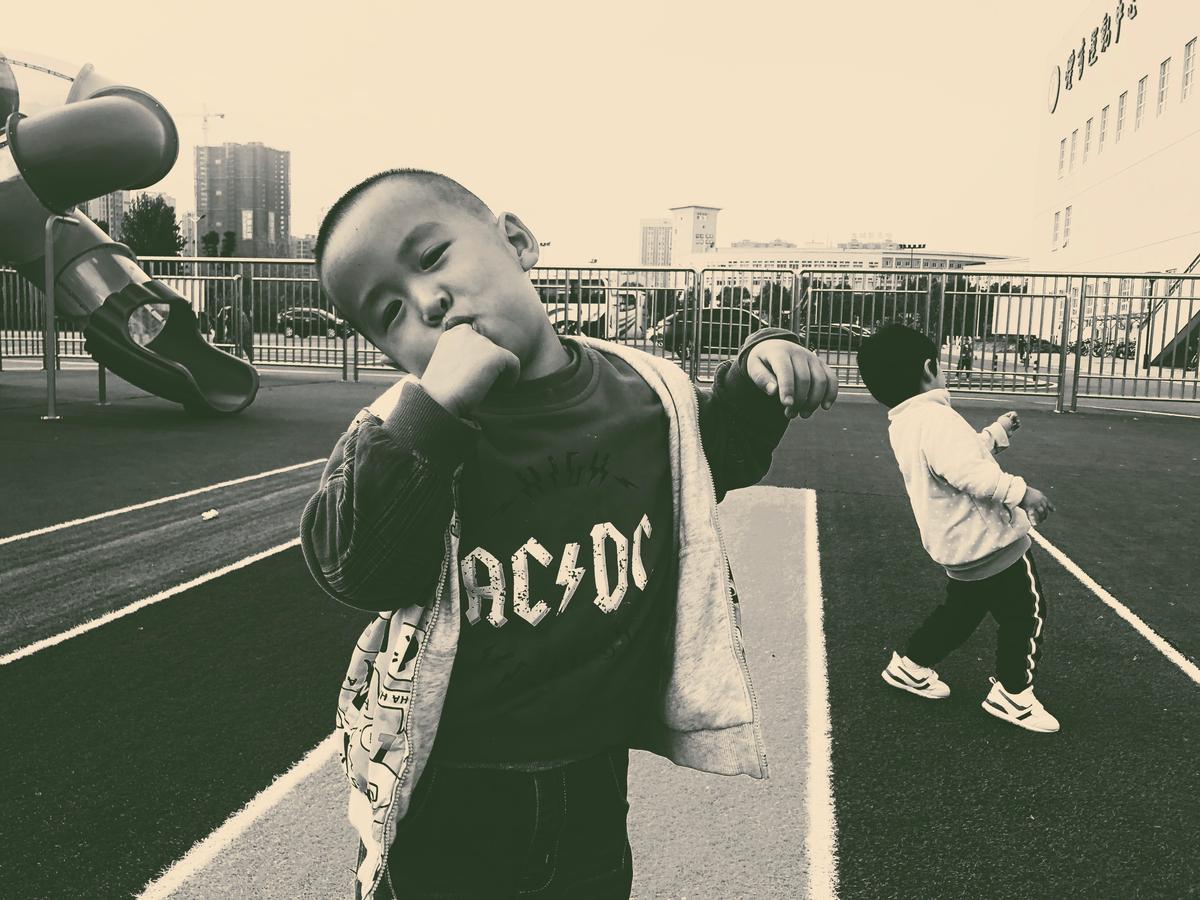 Weitong Li;Tiny Rock Stars;I accidentally captured this photo. The kindergartener, wearing an ACDC band top, moves like the lead singer, and the child behind him happens to be posing to play the guitar. Two tiny rock stars shows themselves in front of the camera.