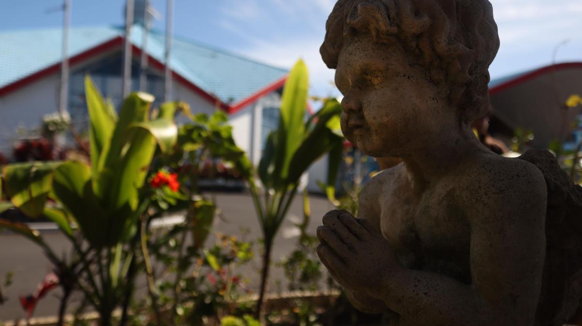 Rose Fifita;Heaven, close to earth;An angel child carved in stone, hands folded in prayer. The church sits just behind. It almost feels like he’s watching over it, quietly. There’s something peaceful and sacred about this little corner.