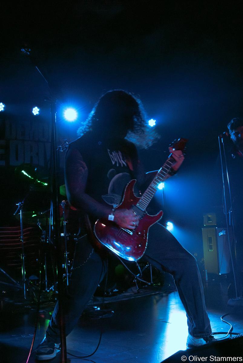 Oliver Stammers;Standing out.;Highlighting the ruby red guitar of an opening band as it plays a melody throughout the crowd.