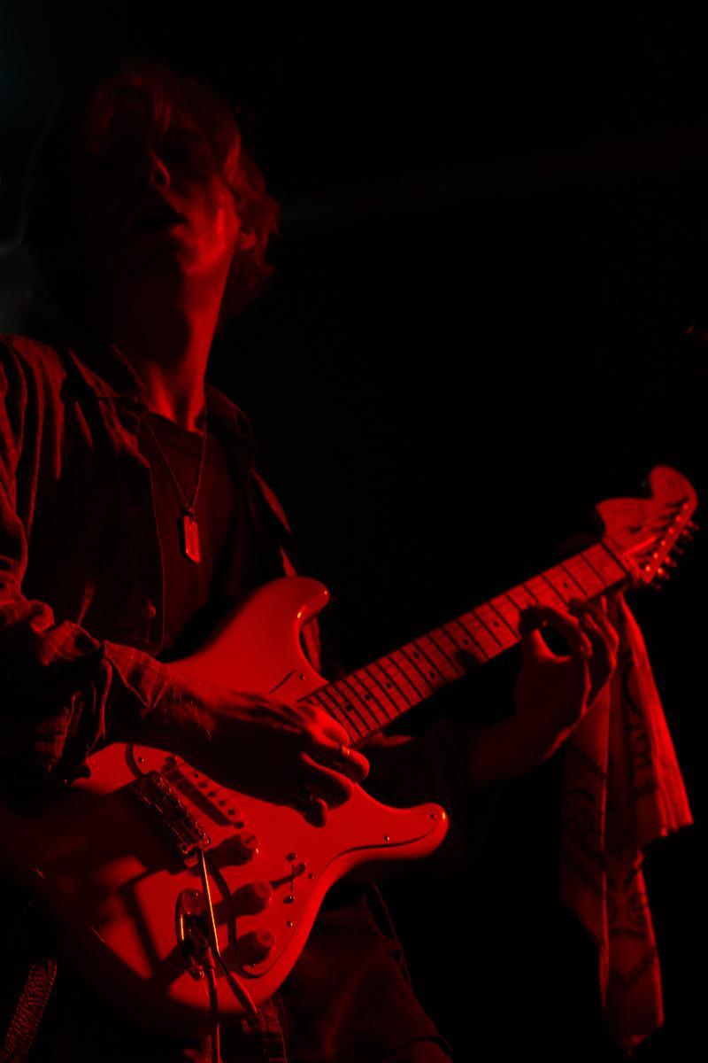 Georgia Fitzpatrick; Rory Seraphim;A bassist harshly contrasted in illuminance red